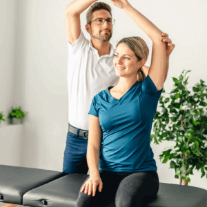 Man raising a female patient’s left arm. Man raising a female patient’s left arm.
